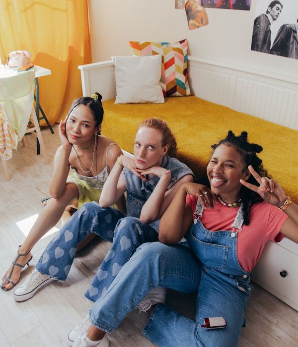 A diverse group of people smiling and sitting comfortably on yoga mats.