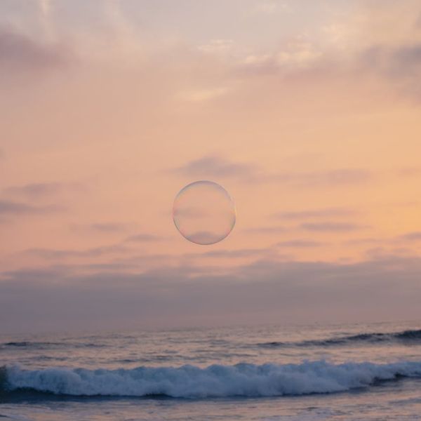 Calm person meditating with a serene pastel blue background.